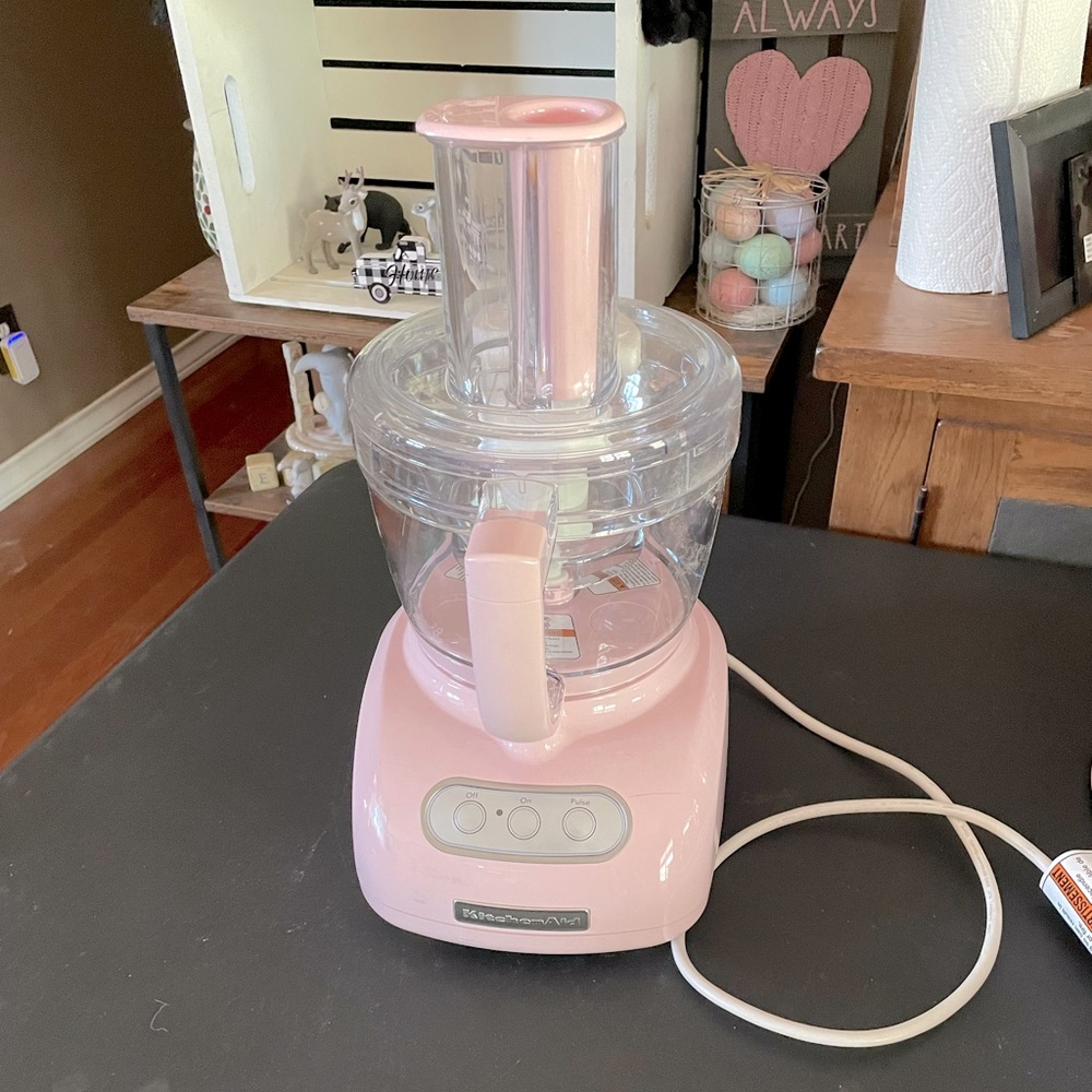 Pink Kitchenaid 12 cup food processor with pink cover and instruction booklet.